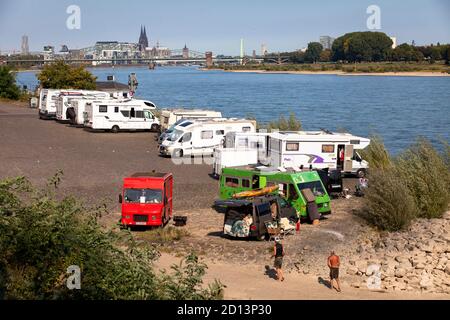 Camper sulle rive del Reno nel quartiere Rodenkirchen, vista sulla città, il porto di Rheinau e la cattedrale, Colonia, Germania. Wohnmobi Foto Stock
