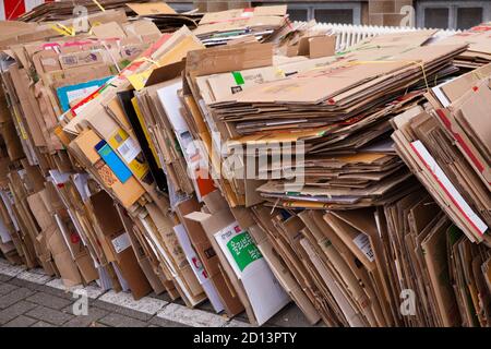 Scatole di cartone smontate e impaccate giacciono sul marciapiede per lo smaltimento, Colonia, Germania. Zerlegte und gebuendelte Pappkartons liegen zum Abtransp Foto Stock