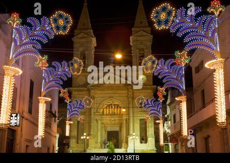 La Basilica dei Santi Cosma e Damiano su Piazza Curri illuminata in tarda serata, Alberobello, Puglia, Italia Foto Stock