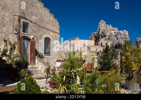 Una casa e giardino cortile sul Rione Malve, Sasso Caveoso, con la protuberanza conica del Monte Errone oltre, Matera, Basilicata, Italia Foto Stock