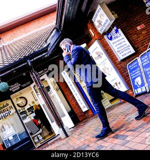 Londra UK, ottobre 05 2020, uomo d'affari che utilizza uno smartphone mobile al di fuori DI UN centro commerciale Foto Stock