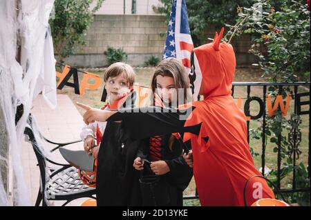 I bambini trick-or-treating su Halloween in una casa decorata Foto Stock
