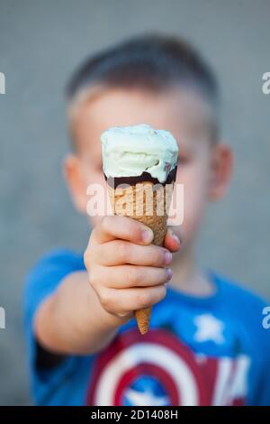 Il clacson del gelato si avvicina in una mano del peperoncino. Foto verticale. Foto Stock