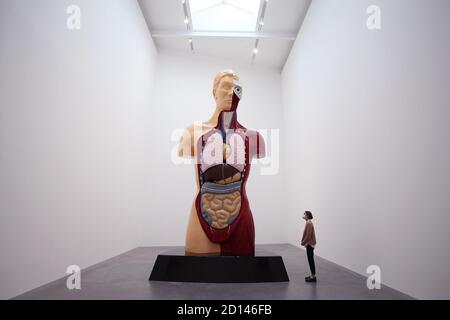 Un membro del personale della galleria si pone accanto a 'Hymn', 1999, durante un'anteprima della mostra personale di Damien Hirst intitolata 'fine di un secolo' alla Newport Street Gallery di Londra, Che sarà caratterizzato da oltre cinquanta opere d'arte che dureranno gli anni formativi di Hirst come studente negli anni '80 fino a diventare uno dei principali artisti contemporanei britannici durante gli anni '90. Foto Stock