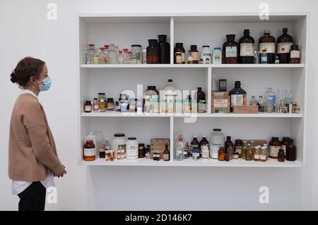 Un membro del personale della galleria si pone accanto al 'COSH', 1990, durante un'anteprima della mostra personale di Damien Hirst intitolata 'fine di un secolo' alla Newport Street Gallery di Londra, Che sarà caratterizzato da oltre cinquanta opere d'arte che dureranno gli anni formativi di Hirst come studente negli anni '80 fino a diventare uno dei principali artisti contemporanei britannici durante gli anni '90. Foto Stock