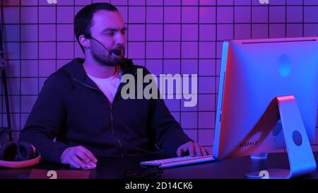Giovane programmatore o hacker che lavora sul computer durante la notte. Foto Stock