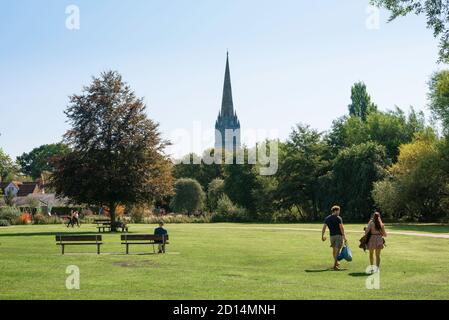 Inghilterra tradizionale, vista in estate di una giovane coppia a piedi attraverso Churchill Gardens Park a Salisbury, Wiltshire, Inghilterra, Regno Unito Foto Stock