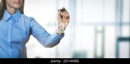 donna scrivono qualcosa con il marcatore nero sullo sfondo dell'ufficio. banner copia spazio Foto Stock