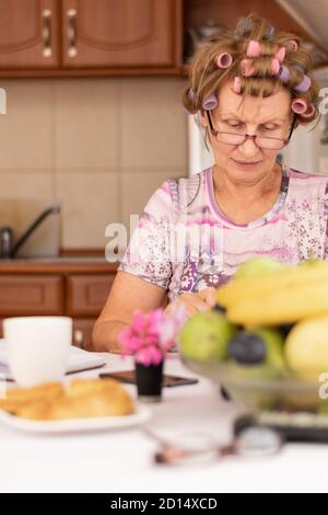 Casalinga che siede in cucina che prende la cura per il preventivo domestico Foto Stock