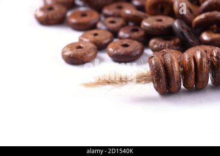 Perline di legno con corda di iuta naturale spago su sfondo bianco. Primo piano, macro. Foto Stock