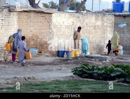 I cittadini stanno riempiendo le loro lattine d'acqua dal rubinetto pubblico in quanto si trovano ad affrontare la carenza di acqua potabile nella loro zona durante il tempo caldo, presso la colonia ferroviaria di Quetta lunedì 05 ottobre 2020. Foto Stock