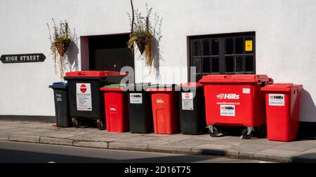 Malmesbury, Wiltshire, Inghilterra, Regno Unito. 2020. Bidoni di riciclaggio neri e rossi contro un muro di pub vicino al centro della città di Malmesbury, Regno Unito. Foto Stock