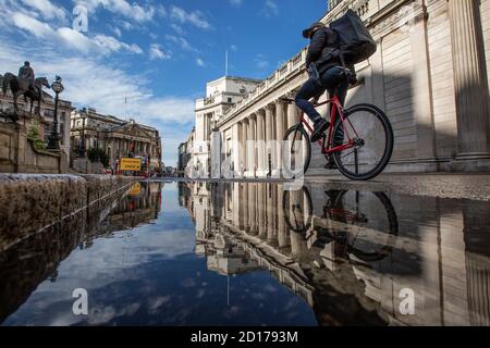 Bank of England e area di Royal Exchange nel cuore del quartiere finanziario della città di Londra si riflettono in un pozze su Threadneedle Street, Londra. Foto Stock