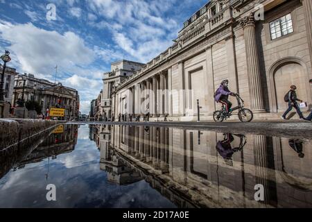 Bank of England e area di Royal Exchange nel cuore del quartiere finanziario della città di Londra si riflettono in un pozze su Threadneedle Street, Londra. Foto Stock