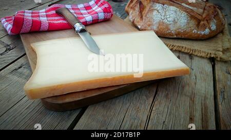 Pezzi di formaggio Abondance su un tagliere Foto Stock