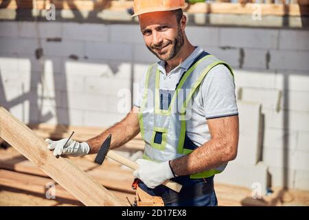 Ritratto di felice lavoratore che tiene in mano il martello Foto Stock