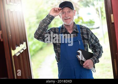 Ritratto di riparatore in piedi all'ingresso di una casa Foto Stock
