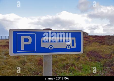 Cartello blu e bianco del parcheggio degli autobus in Scozia, Regno Unito con sfondo rurale, cielo blu e nuvole. Preso a Kilt Rock, Isola di Skye. Foto Stock