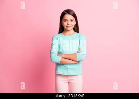 Ritratto fotografico di carina dolce piccola ragazza ispanica sorridente mani incrociate isolate su sfondo di colore rosa Foto Stock