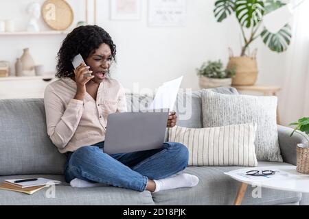 Sollecitazione di lavoro remota. Donna africana arrabbiata che ha problemi mentre lavora a casa Foto Stock