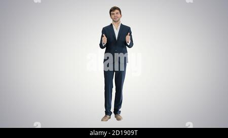 Uomo d'affari sicuro che mostra i pollici in su e gesti ok sul gradi Foto Stock