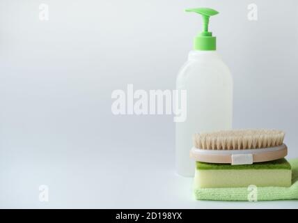 home chores concept. detergente liquido, spazzola detergente, spugna e straccio. set verde per la pulizia della casa. pulizia e pulizia. routine quotidiana. Foto Stock