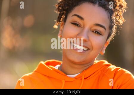 Ritratto all'aperto di bella felice gara mista biraciale African American ragazza adolescente femmina giovane donna ridendo e sorridendo con denti perfetti in g Foto Stock