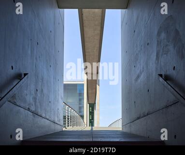 Punto di vista ad angolo basso del telaio della porta di La scala e il ponte pedonale vuoto presso il governo di Berlino distretto Foto Stock