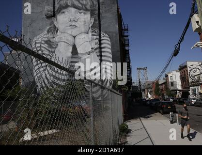 Williamsburg, Stati Uniti. 05 ottobre 2020. Un uomo cammina il suo cane oltre il murale intitolato "Mona Lisa of Williamsburg" a South Williamsburg a New York City lunedì 5 ottobre 2020. Il sindaco Bill de Blasio ha annunciato il suo piano di chiudere le scuole e le attività non essenziali ancora in nove codici di avviamento postale attraverso Brooklyn e Queens la domenica a causa di un picco nelle infezioni da Coronavirus. Foto di John Angelillo/UPI Credit: UPI/Alamy Live News Foto Stock