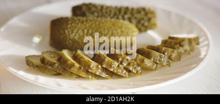 cetrioli fermentati, cetrioli marinati sottaceto su un piatto. sano spuntino vegano pieno di probiotici salute e digestione dell'intestino. vista banner, cetrioli fatti in casa in scatola. Foto Stock