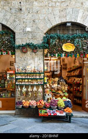 L'esterno di un negozio di alimentari nel centro storico con frutta fresca e verdure esposte sul marciapiede, Siena, Toscana, Italia Foto Stock