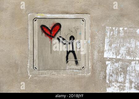Primo piano di un graffito dell'artista di strada italiano uscita entrare (.K) sul contatore elettrico di un vecchio muro nel centro della città di Siena, Toscana, Italia Foto Stock