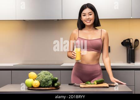 Allegra Slim Giapponese Donna bere succo di cucina cena in cucina Foto Stock