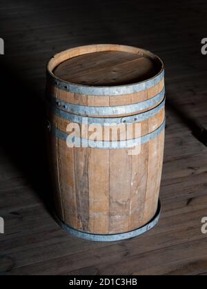 Vecchio barile di legno marrone su un pavimento di legno Foto Stock