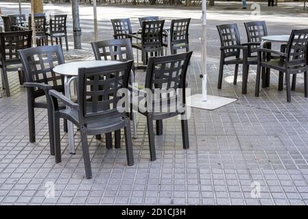 Tavoli e sedie da un bar situato sulla strada senza che nessuno li usi. Foto Stock