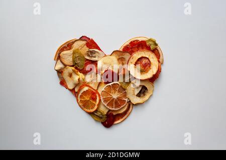 Colorate fette di frutta secca cuore isolato su sfondo bianco Foto Stock