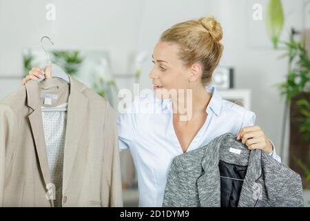 donna scelta giacca in boutique Foto Stock