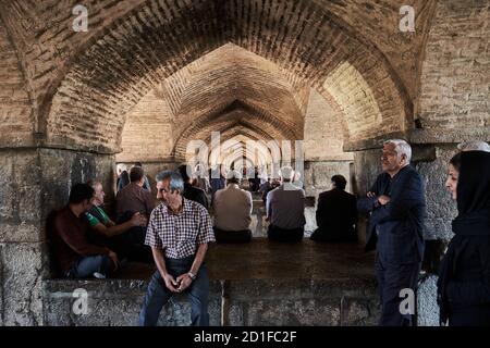 Un gruppo di uomini si riuniscono per cantare sotto il ponte Khaju, in un pomeriggio di domenica, a Isfahan, Iran Foto Stock