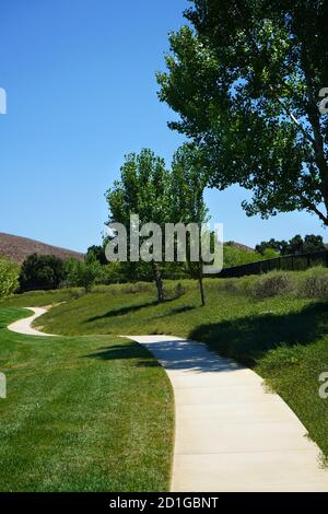 Una passeggiata tortuosa attraverso un parco in una giornata di sole. Foto Stock