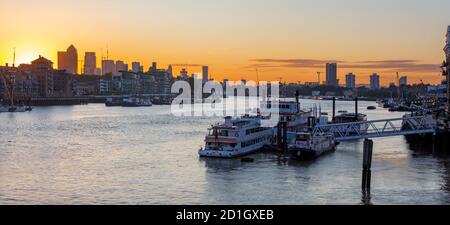 Londra - Le navi ormeggiate al molo e il Canary Wharf in mattina. Foto Stock