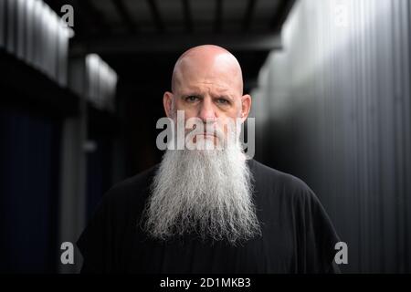 Stressato uomo calvo maturo che guarda sconvolto nelle strade all'aperto Foto Stock