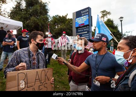 Bethesda, MD, USA, 5 ottobre 2020. Nella foto: Un sostenitore di Black Lives Martter si unì alla folla riunita fuori dal Walter Reed National Military Medical Center Trump fu ricoverato in ospedale per la covid-19 dopo aver contratto il romanzo coronavirus. Molti sostenitori erano verbalmente aggressivi nei suoi confronti, facendo domande, ma non permettendogli di rispondere, compreso questo reporter dalla destra. Non ha mai perso il suo freddo, e ha continuato a spiegare pazientemente le sue ragioni per essere lì, nonostante le frequenti e forti interruzioni. Credit: Alison C Bailey/Alamy Live News Foto Stock