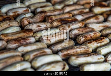 Banana arrostita su stufa a carbone a cibo di strada. Banana alla griglia, cibo sano. Focalizzazione selettiva. Foto Stock