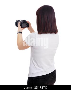 vista posteriore di una fotografa femminile o di un videografo che scatta un video o. scattare foto sulla sua fotocamera dslr isolata su sfondo bianco Foto Stock