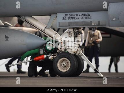 Aviation Boatswain’s Mate (Equipment) 3a Classe Brithza Mora, da Sierra Vista, Arizona, posiziona una barra di attesa su un F/A-18E Super Hornet, attaccato ai Dambusters of Strike Fighter Squadron (VFA) 195, mentre si prepara al lancio dal ponte di volo dell'unica portaerei della Marina USS Ronald Reagan (CVN 76). Ronald Reagan, il fiore all'occhiello del Carrier Strike Group 5, fornisce una forza pronta per il combattimento che protegge e difende gli Stati Uniti, nonché gli interessi marittimi collettivi dei suoi alleati e partner nell'Indo-Pacifico. (STATI UNITI Navy foto di Mass Communication Speci Foto Stock