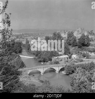 DINHAM BRIDGE, Ludlow, Shropshire. Vista generale da una posizione elevata che mostra il fiume Teme in primo piano. Il ponte Dinham a Ludlow fu costruito nel 1823. La presenza dominante del castello di Ludlow si può vedere sullo sfondo. Fotografato da Eric de Mare tra il 1945 e il 1980. Foto Stock