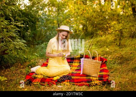 immagine di una ragazza in un vestito giallo in a. cappello di paglia con mele Foto Stock