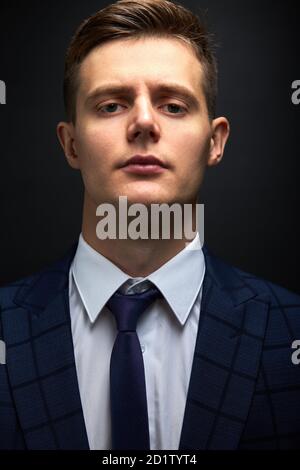 sicuro ragazzo caucasico trendy in abito elegante formale che posa isolato su sfondo nero, prospero presentabile maschio ha il proprio commercio Foto Stock