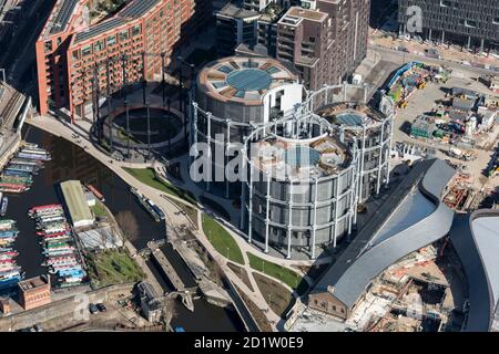 Gasholders 10, 11 e 12, noto anche come 'Triplet Siamese' restaurato e rieretto intorno ad una serie di edifici di appartamenti e St Pancras Lock, Kings Cross, Londra, 2018, Regno Unito. Vista aerea. Foto Stock