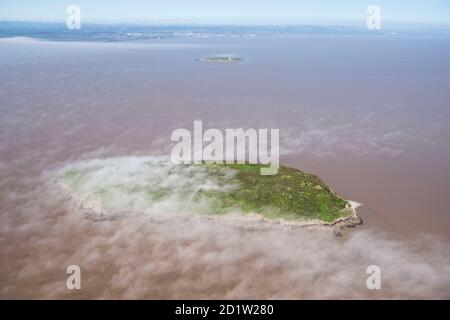 Bassa nuvola sull'isola di Holm ripida, da sud guardando verso Flat Holm, Somerset Nord, Regno Unito. Vista aerea. Foto Stock